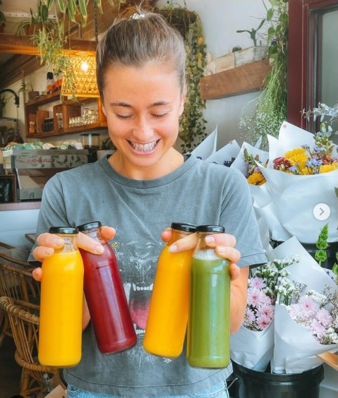Papaya Lennox Cafe Girl holding up fresh juice